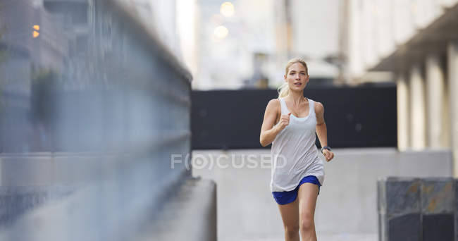 Woman running through city streets — Stock Photo