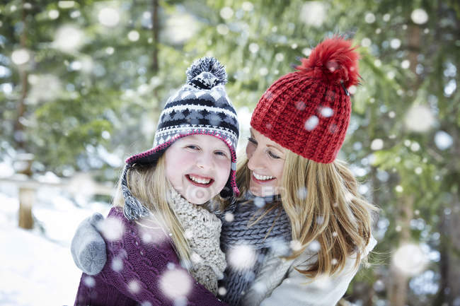 Mère et fille étreignant dans la neige — Photo de stock