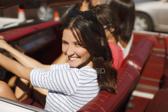 Улыбающиеся женщины за рулем кабриолета — стоковое фото