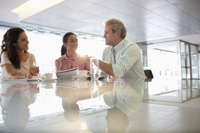 Деловые люди разговаривают в лобби в современном офисе — стоковое фото