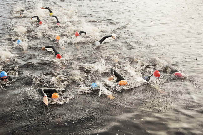 Уверенные и сильные триатлонисты, плавающие в воде — стоковое фото