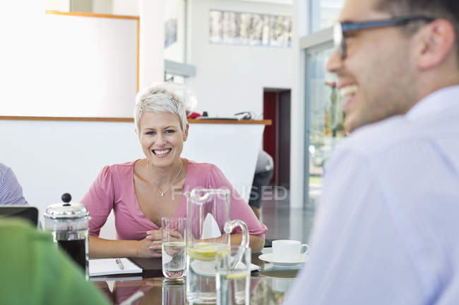 Ділові люди посміхаються на зустрічі в сучасному офісі — стокове фото