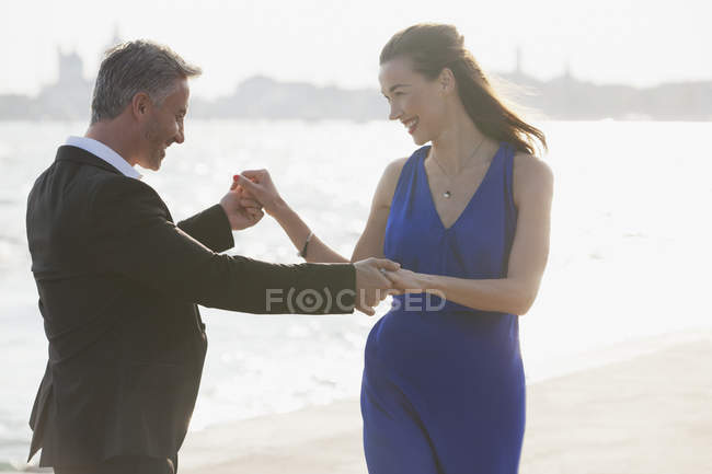 Joyeux couple bien habillé dansant au bord de l'eau à Venise — Photo de stock