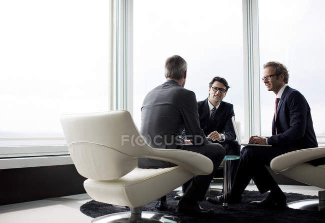 Businessmen talking at modern office lobby — Stock Photo
