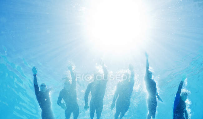 Confident and strong triathletes in wetsuits underwater — Stock Photo