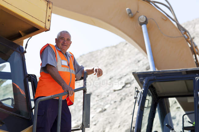 Worker standing on machinery on site — Stock Photo