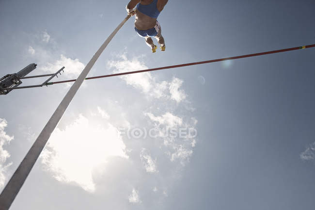Pole vaulter clearing bar — Stock Photo