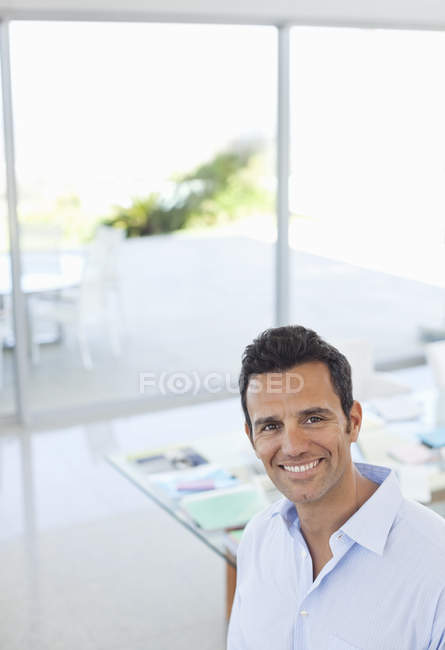 Kaukasischer Geschäftsmann lächelt über modernes Büro — Stockfoto