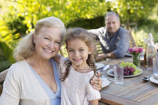 Літня жінка і онука посміхаються на відкритому повітрі — стокове фото