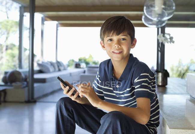 Хлопчик використовує мобільний телефон на кроках — стокове фото
