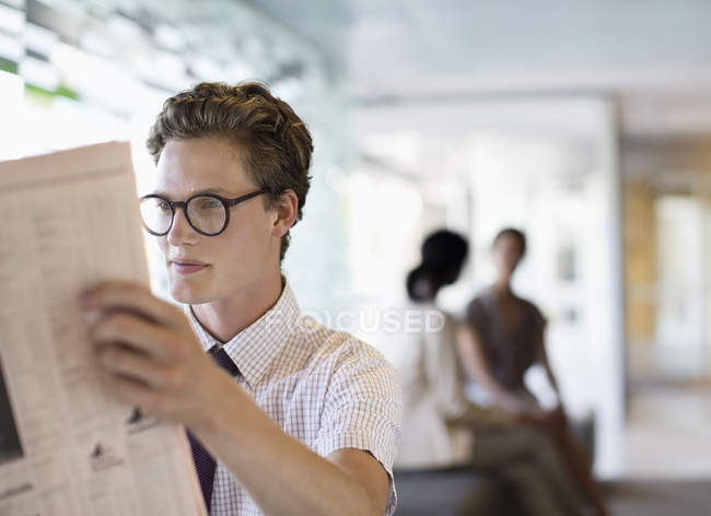 Geschäftsmann liest Zeitung im modernen Büro — Stockfoto