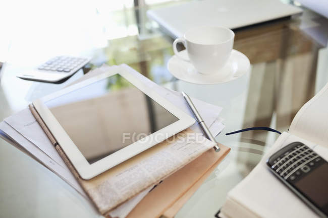 Tablette, journal, tasse à café et téléphone portable sur le bureau — Photo de stock