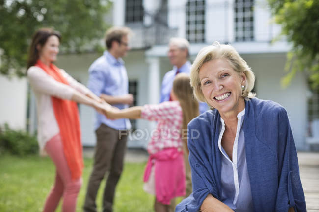 Mulher sorridente sentada ao ar livre — Fotografia de Stock