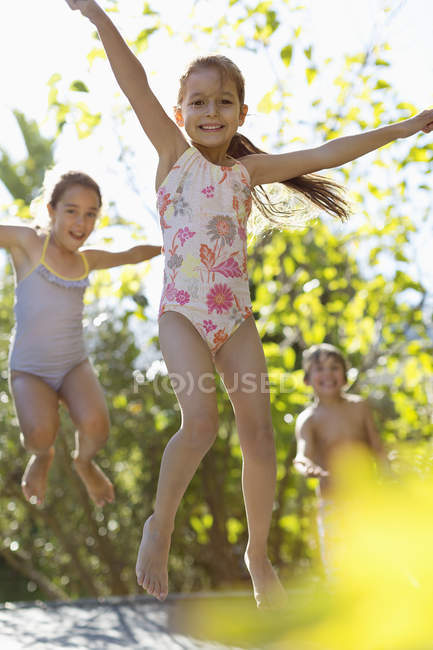 Niños saltando en el trampolín al aire libre - foto de stock