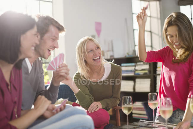Amigos jugando juegos de cartas en la sala de estar - foto de stock