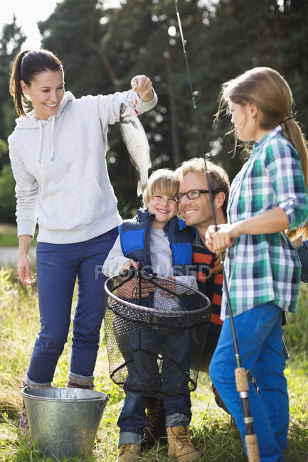 Family admiring fishing catch — Stock Photo