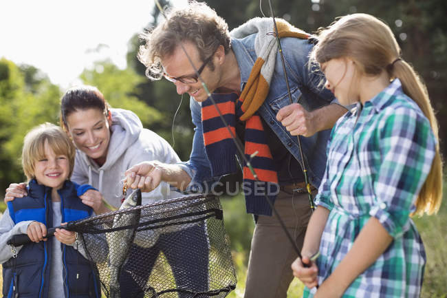 Family admiring fishing catch — Stock Photo