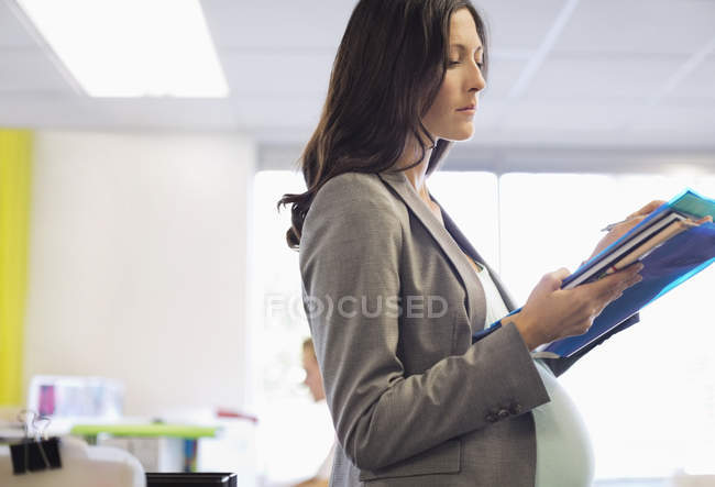 Pregnant businesswoman working in office — Stock Photo
