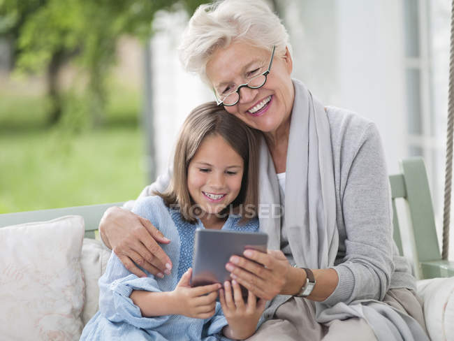 Femme et petite-fille utilisant une tablette numérique — Photo de stock
