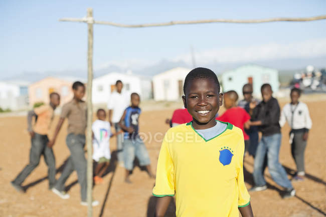 Menino africano sorrindo no campo de sujeira — Fotografia de Stock
