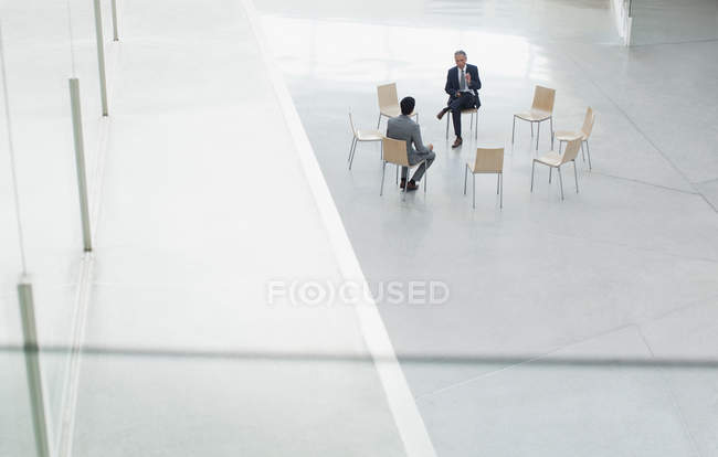 Reunión de empresarios en el círculo de sillas en el vestíbulo - foto de stock