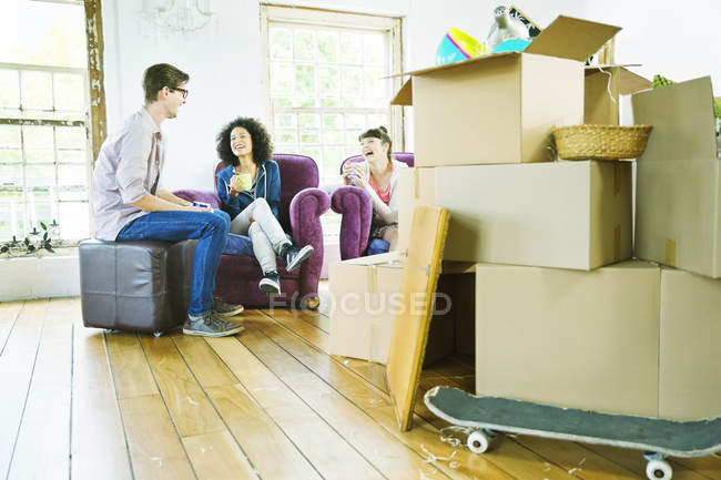 Young happy friends relaxing in new home — Stock Photo