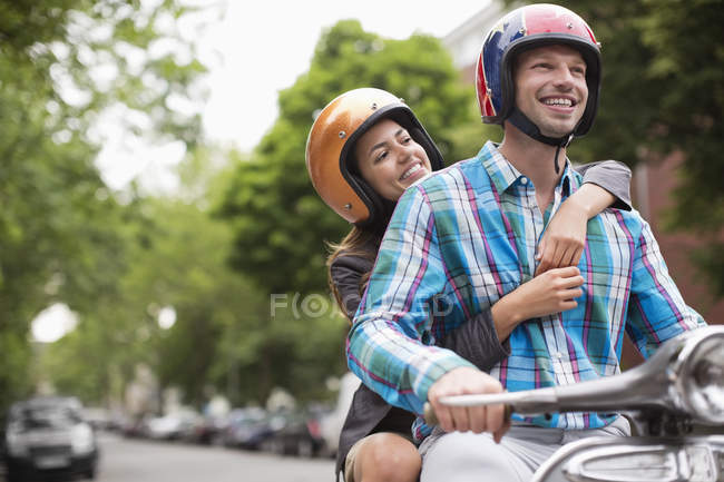 Couple riding scooter together outdoors — Stock Photo