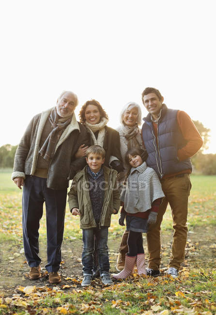 Familia sonriendo juntos en el parque - foto de stock