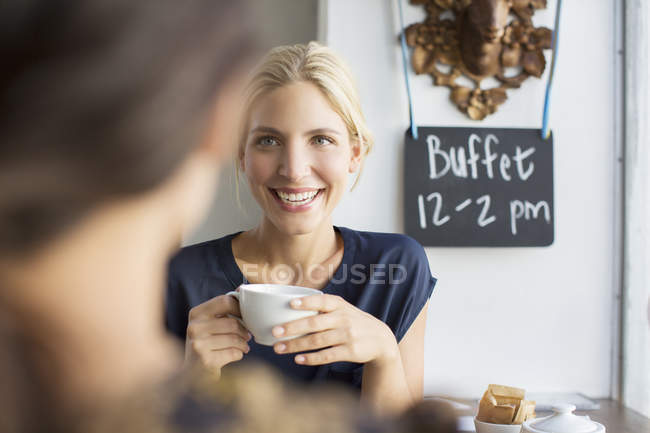 Women having coffee together in cafe — Stock Photo