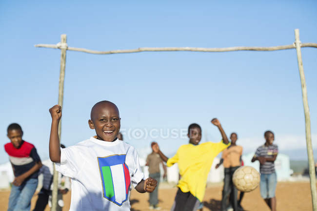 African boys  playing soccer together in dirt field — Stock Photo