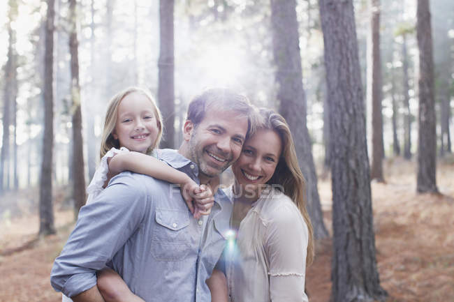 Retrato de família sorridente em bosques ensolarados — Fotografia de Stock