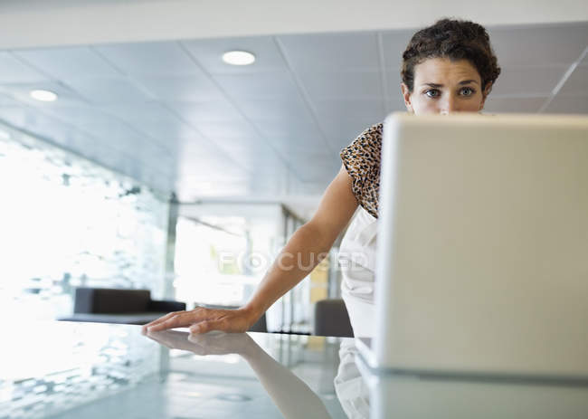 Donna d'affari che lavora al computer portatile alla scrivania presso l'ufficio moderno — Foto stock