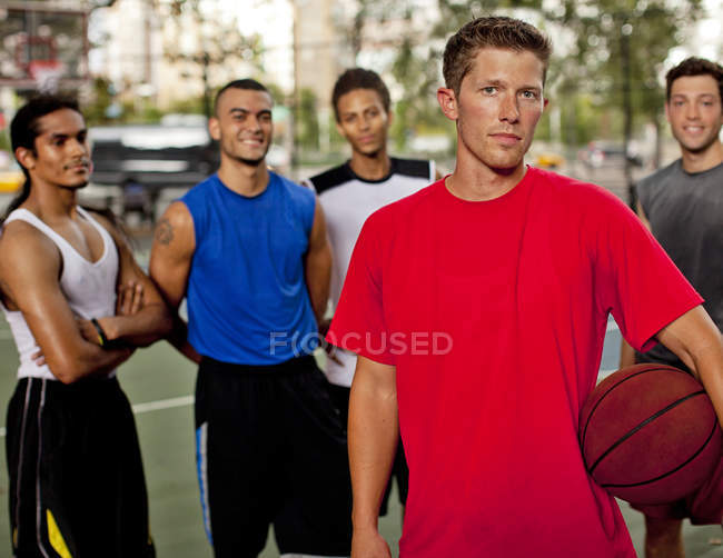 Group of athletic men standing on basketball court — Stock Photo