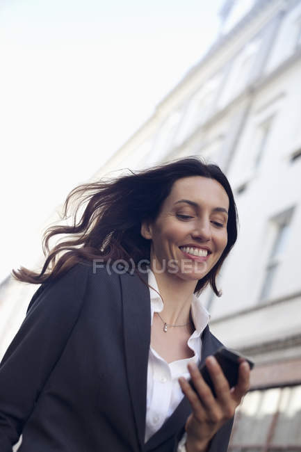 Happy businesswoman text messaging with cell phone — Stock Photo