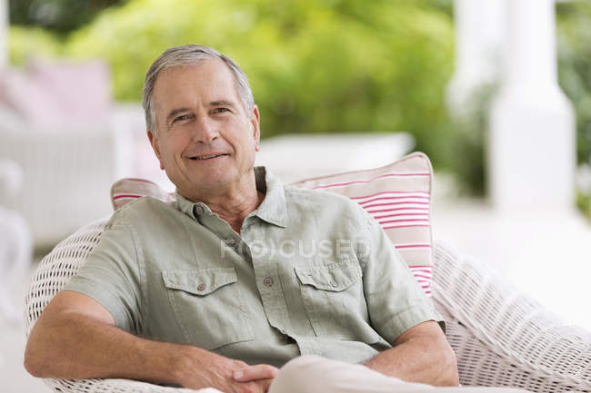 Älterer Mann sitzt im Sessel im Freien — Stockfoto