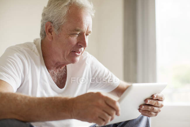 Uomo anziano utilizzando tablet digitale — Foto stock