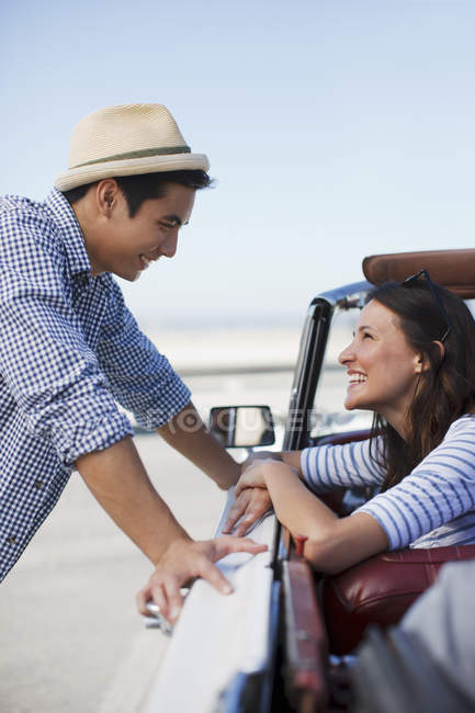Улыбающаяся пара разговаривает в кабриолете — стоковое фото