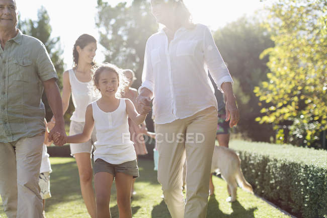 Familia feliz caminando juntos en el patio trasero - foto de stock