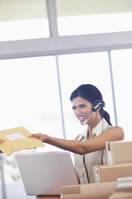 Femme d'affaires acceptant les paquets au bureau moderne — Photo de stock