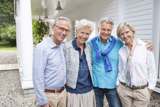 Friends standing together outside house — Stock Photo