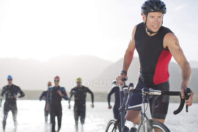 Triathletes emerging from water — Stock Photo