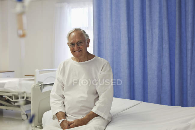 Älterer Patient sitzt auf Krankenhausbett — Stockfoto
