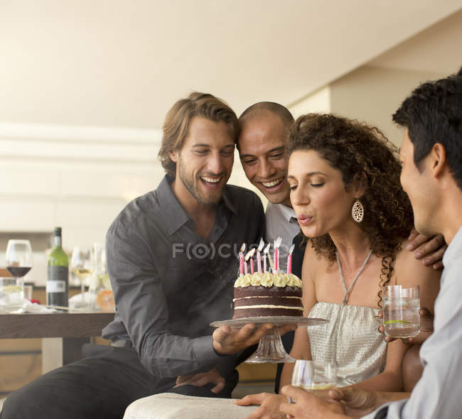 Giovane attraente donna soffiando candele di compleanno — Foto stock