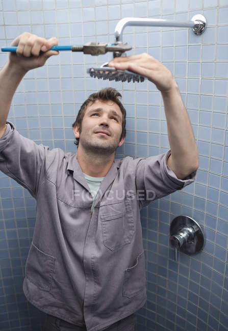 Idraulico che lavora sul soffione doccia in bagno — Foto stock