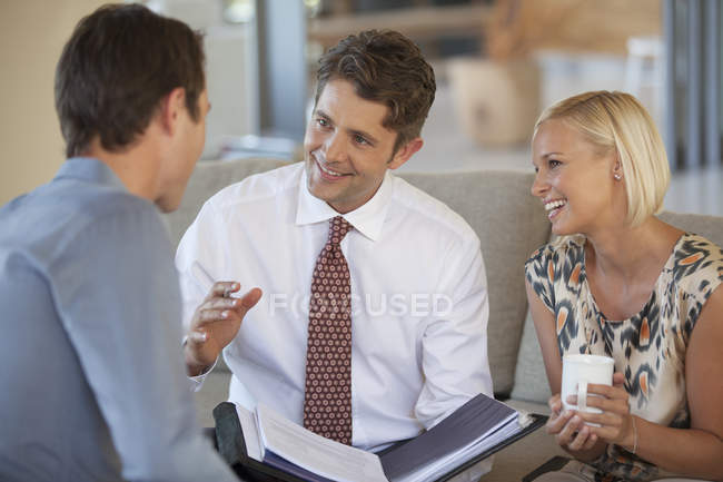 Финансовый консультант разговаривает с парой на диване — стоковое фото