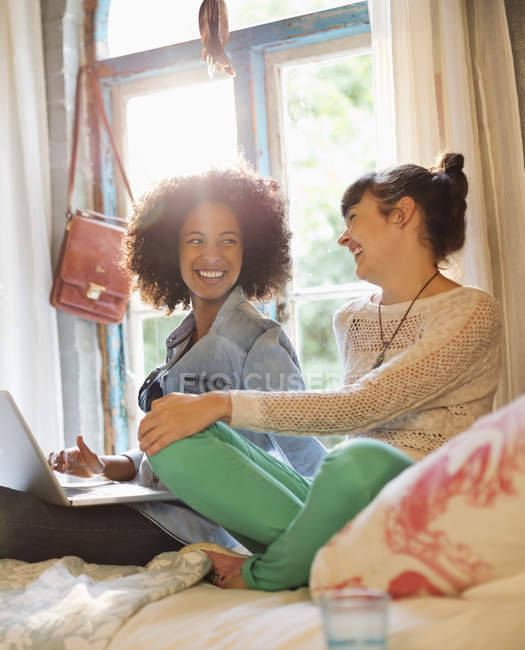 Giovani donne felici rilassarsi insieme in camera da letto — Foto stock