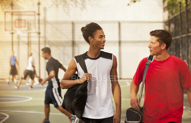 Мужчины разговаривают на баскетбольной площадке — стоковое фото
