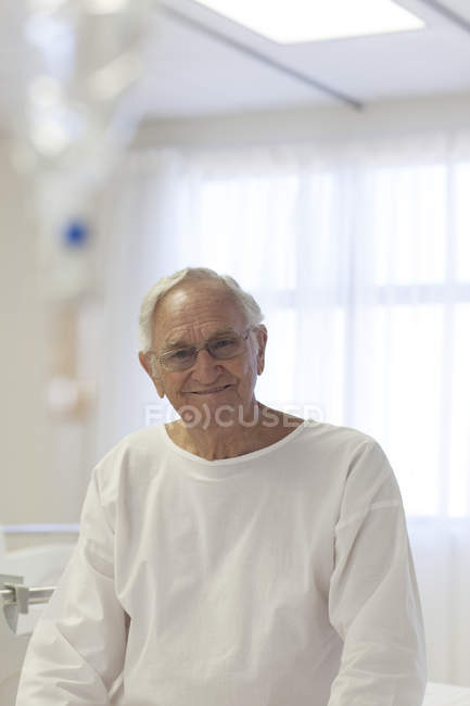 Paciente mayor sonriendo en la habitación del hospital - foto de stock