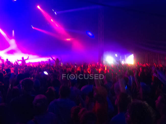 Crowd frente al escenario iluminado - foto de stock