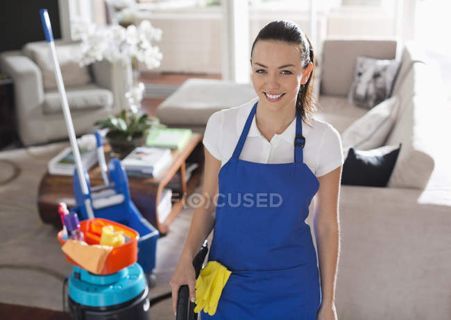 Skillful caucasian maid smiling in living room — Stock Photo